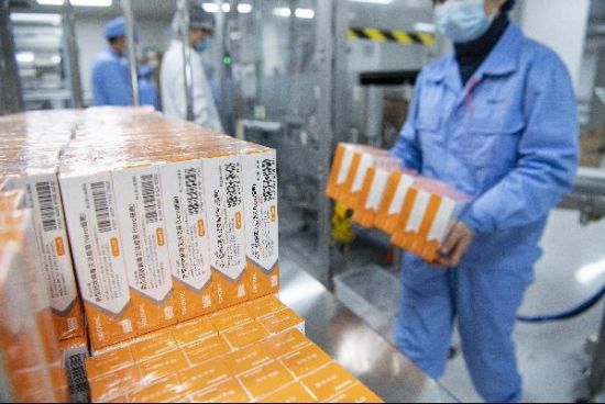 图为工作人员搬运整理包装流水线上的预充式注射器装疫苗.